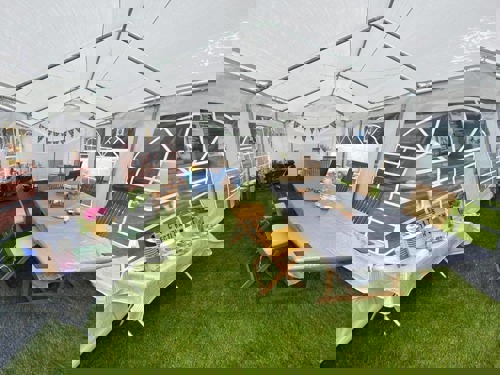 A white marquee on grass with tables inside